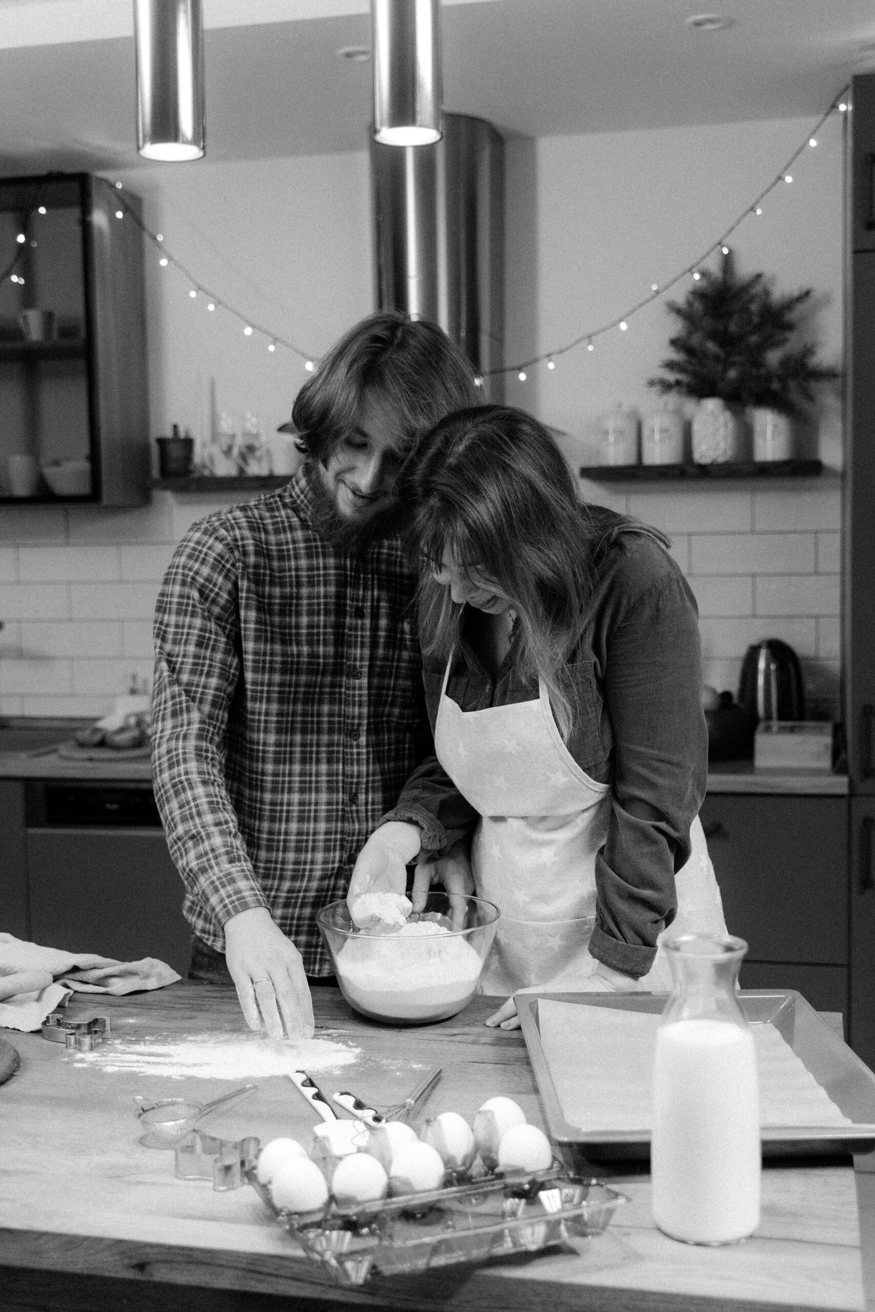 black and white photo of a couple in the kitchen baking together